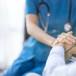 A doctor holds a patient's hands